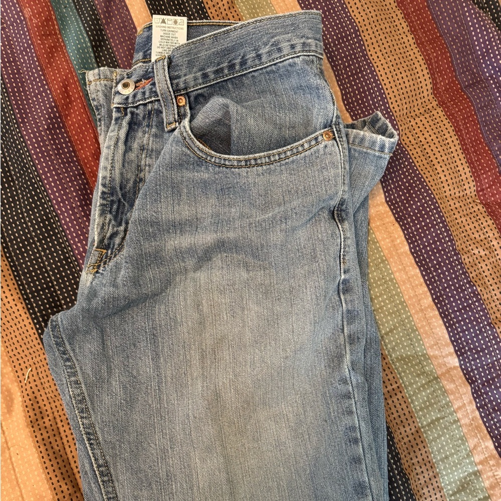 Work jeans with some fraying and holes.